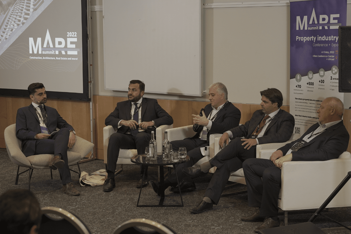 Speakers Douglas Salt, George Vella, David Valenzia, Andrei Imbroll and moderator Liam Carter discussing Panel: Understanding Real Estate Investment: Financial Assets and Real Assets at MARE Summit 2022, Hilton, Malta